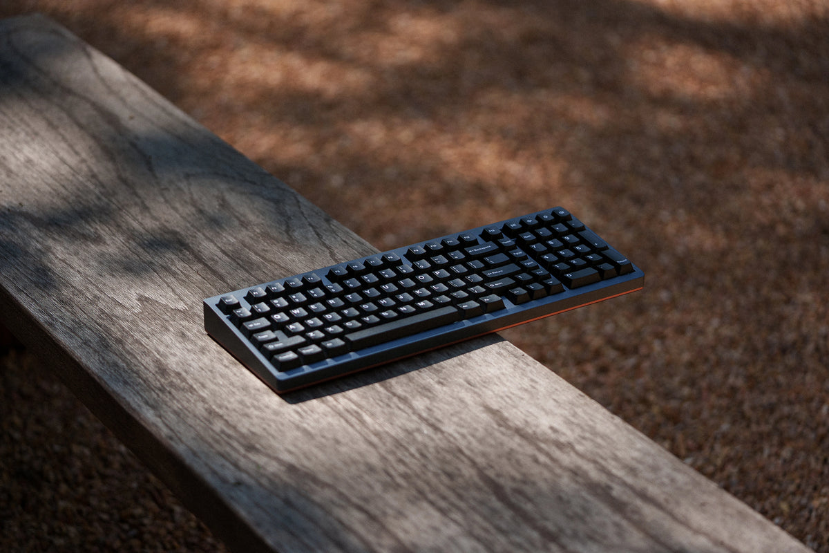 Mode Prologue in Blue Mocha on a weathered wooden bench in dappled shade